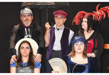 Σκηνή από τη θεατρική παράσταση «Η Δημοκρατία με το Μάτι του Λυγκέα» με ηθοποιούς σε σουρεαλιστικά κοστούμια και έντονα θεατρικά στοιχεία